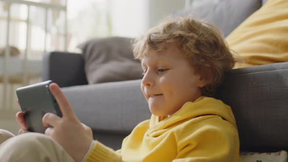 Little Boy Playing Video Game on Tablet