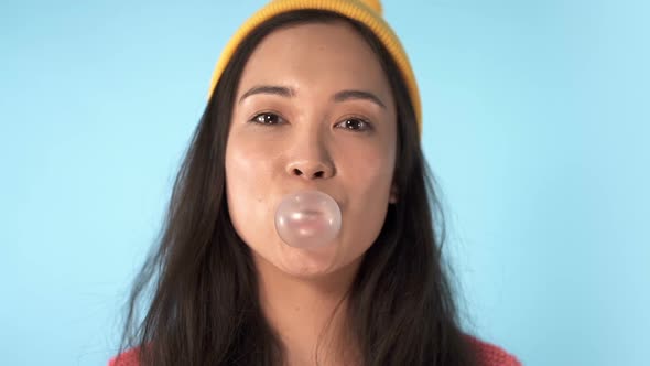 Close up portrait of young asian woman chewing gum.