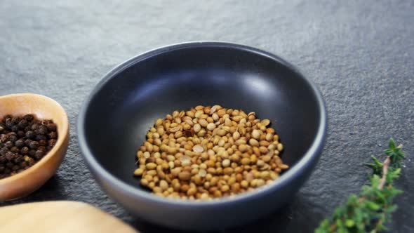 Coriander seeds, black pepper, rosemary herbs and wooden board