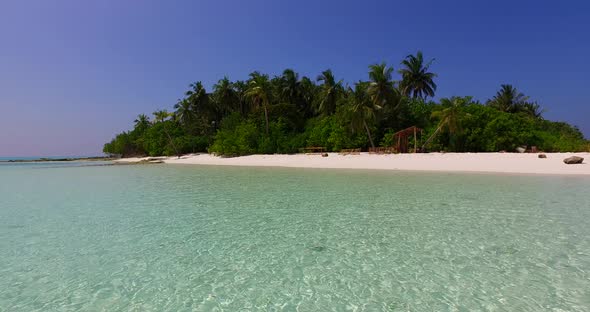 Beautiful fly over tourism shot of a paradise sunny white sand beach and aqua blue ocean background 