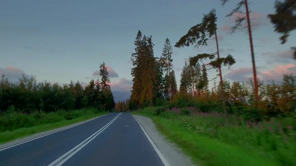 Driving a car on the road between the mountains in the Tatras at sunrise, Poland