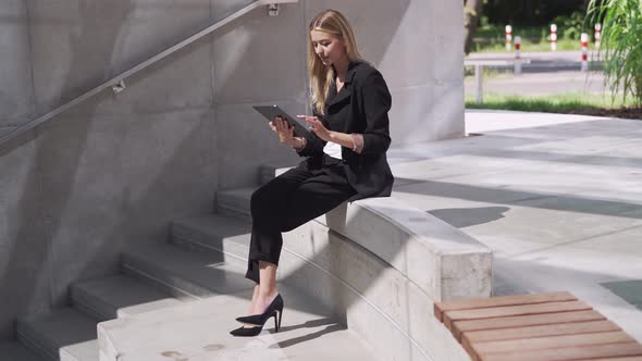 Female Manager Using Tablet on Steps