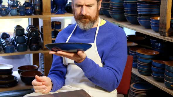 Male potter examining a earthenware bowl