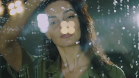 Portrait Through the Glass Door Drops of Woman Caresses Her Hair at Night