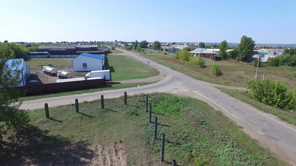 Aerial View of Tank Trucks Riding Into Yard of Beer Manufacture with Buildings Behind Fence in