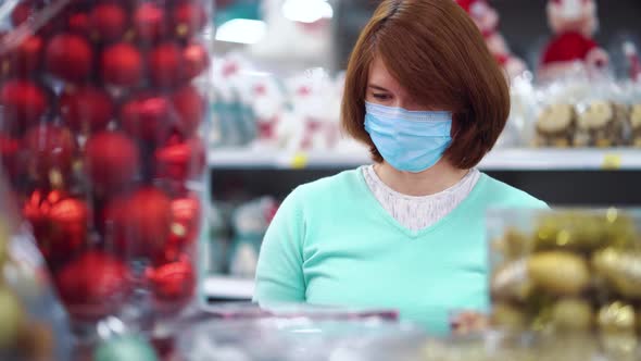 Woman looking at Christmas decorations at store during pandemic