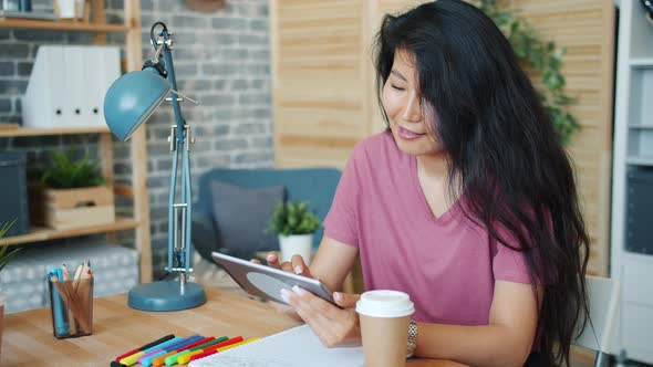 Smiling Asian Woman Office Worker Using Tablet at Work Touching Screen