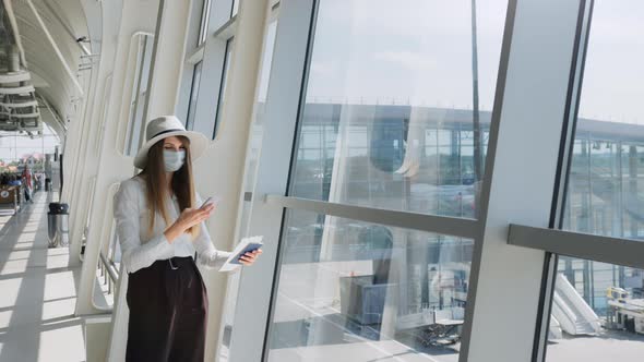 Young Girl Business Woman Standing By the Window in a Modern Airport Holding