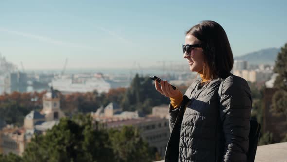 Portrait of Smiling Woman Using Smartphone Voice Recognition