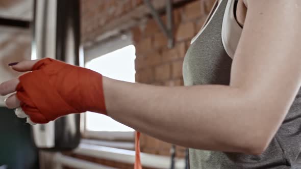 Female Boxer Wrapping Hands with Bandage