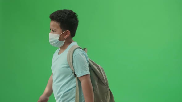 Side View Of Asian Boy Student Walking To School On Green Screen Chroma Key