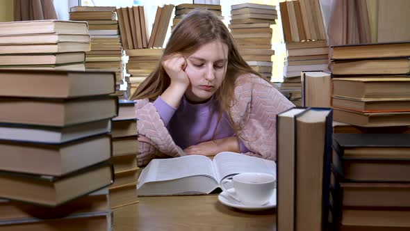 A Girl Reads a Book in the Library