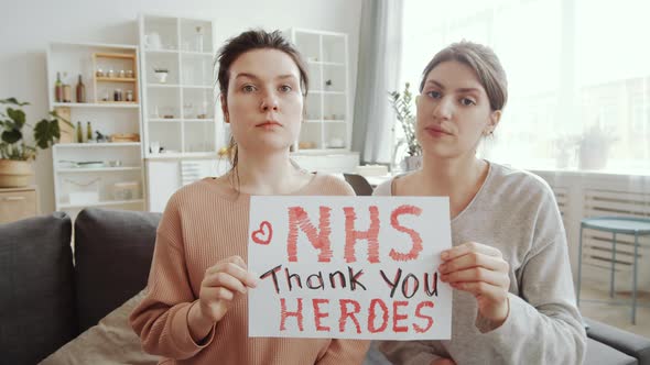 Two Young Women Saying Thanks to NHS at Camera while Staying at Home