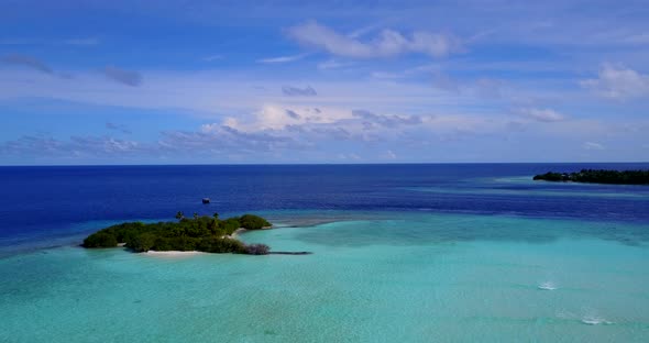 Wide angle birds eye tourism shot of a sandy white paradise beach and aqua turquoise water backgroun