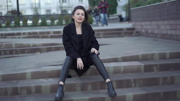 Lady in Black Poses on Street Stairs at Camera