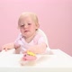 Baby girl sitting in highchair eating cupcake - VideoHive Item for Sale