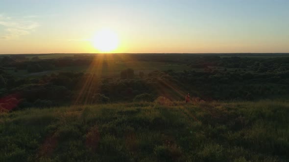 Aerial View Mother and Son Standing on Mountain Cliff Hugging Watching Sunset