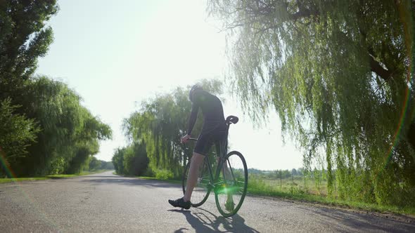 Confused Cyclist on the Empty Road Looking on Sides