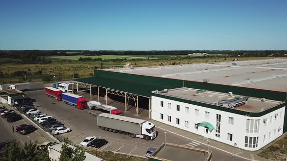 Aerial view of a big factory and a parking lot in the front.