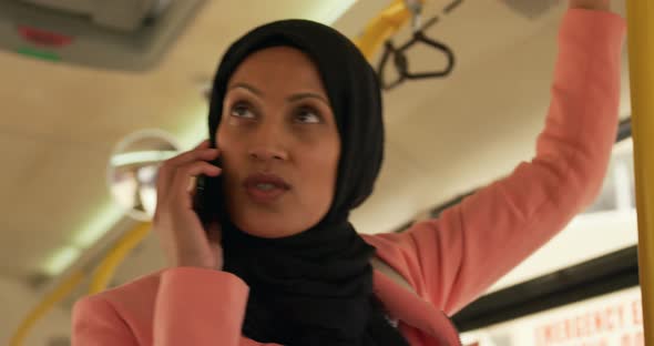 Young woman wearing hijab commuting on a bus