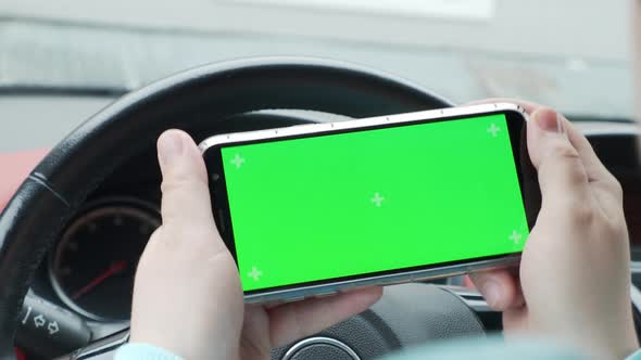 a man in a car holding a phone green screen