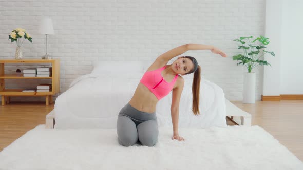 Athletic Healthy Asian woman in sportswear workout excercise at home
