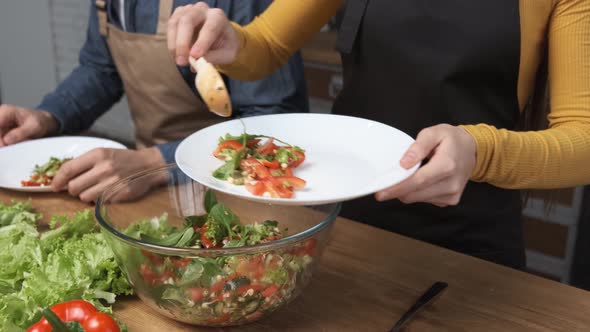 Making Salad at Home A Young Woman Puts Salad on a Plate