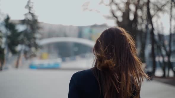 Back view of a woman walking in the autumn park 