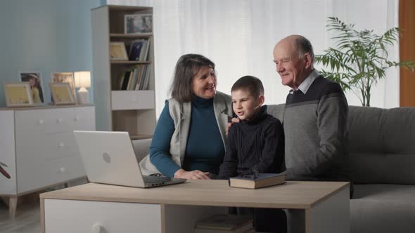 Family Pastime Beloved Grandparents Together with a Smiling Boy Have Fun and Enjoy Watching