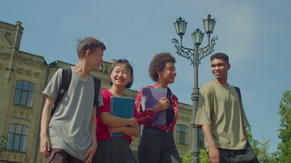 Portrait of Diverse Multicultural Students Chatting While Walking After Study