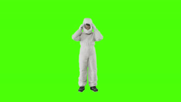 Man in a Spacesuit Stands and Puts on a Helmet  alt
