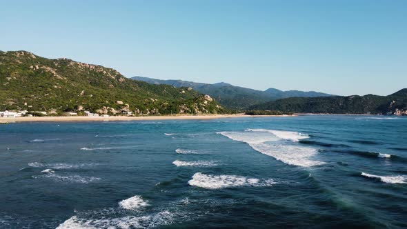 Foamy ocean waves rolling towards exotic tropical coastline of Vietnam, aerial view