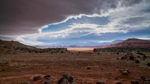 Looking over the red glowing desert during timelapse as clouds roll