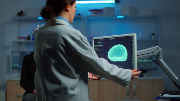 Neurologist Doctor Looking at Monitor Examining Brain Scan