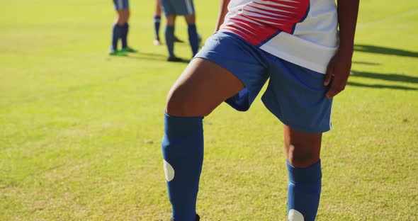 Female soccer player standing with one foot on the ball. 4k