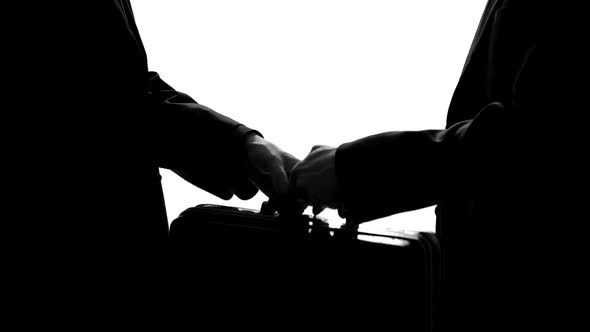 Two Men Handshaking After Transferring Suitcase, Business Agreement, Bribe