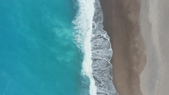 Aerial view sandy beach with white waves