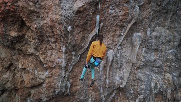 Man Rock Climber Descends From the Challenging Route on Overhanging Crag the Climber Hangs on a Rope