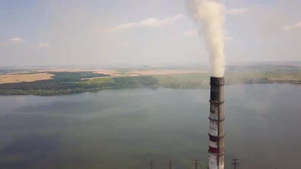 Aerial view of high chimney pipes with grey smoke from coal power plant