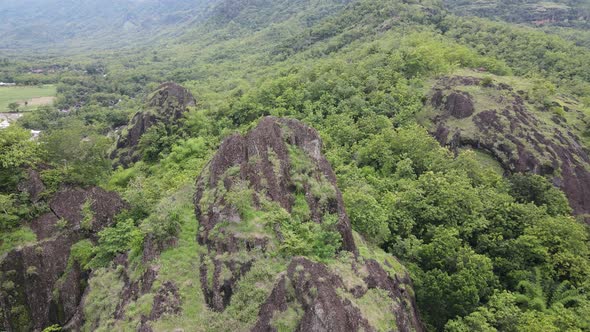 Aerial drone view of rock mountain cliff in the middle of the rice field.