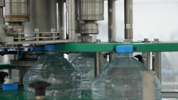 Automatic capping of plastic bottles. Drinking Water Production Line at Food Processing Plant
