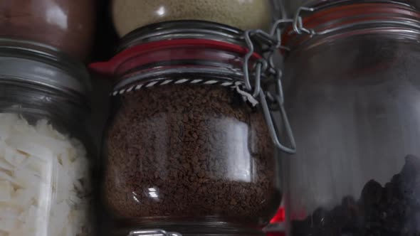 Close up of coffee grounds in Kilner clip top jar in wall of jars.