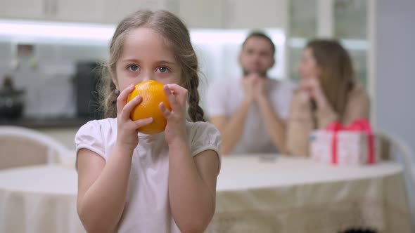 Cheerful Girl Juggling Orange and Smelling Delicious Fruit Looking at Camera Smiling