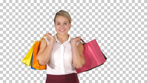 Young woman walking and hold shopping bags while doing