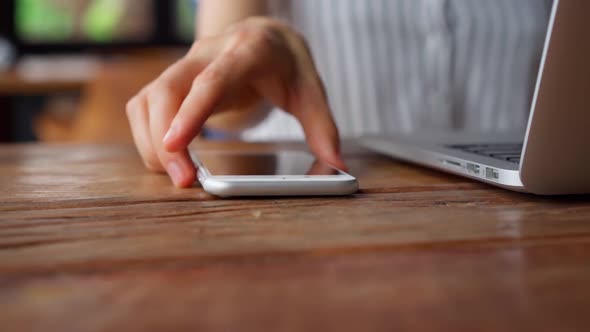 Woman grab smartphone from table and start browsing