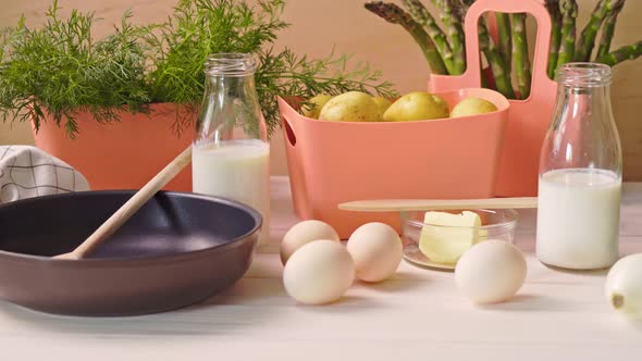 Spring Young Vegetables with Eggs and with Milk and  Frying Pan on  Wooden Table
