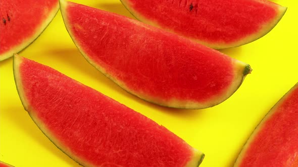Fresh ripe watermelon slices on yellow background.