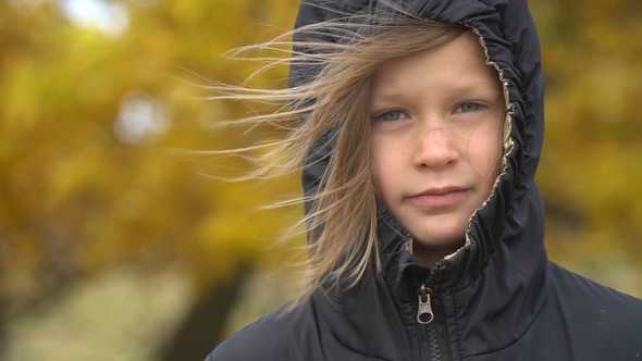 Closeup portrait of a serious adorable little girl. Slow motion.