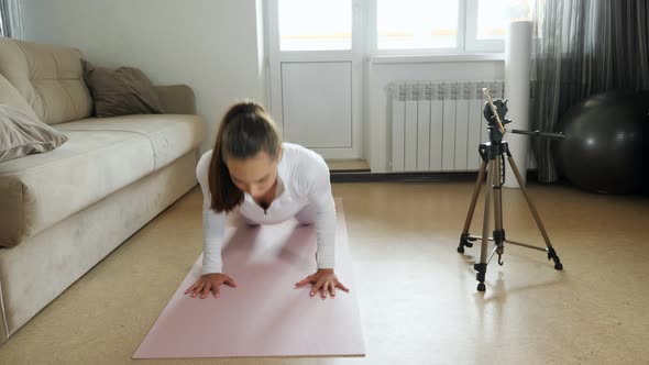 Young Trainer Does Press Ups on Knees Shooting Video at Home