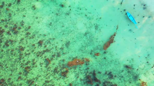 fishing boats floating over the fringing coral reef in the crystal clear turquoise sea water. drone